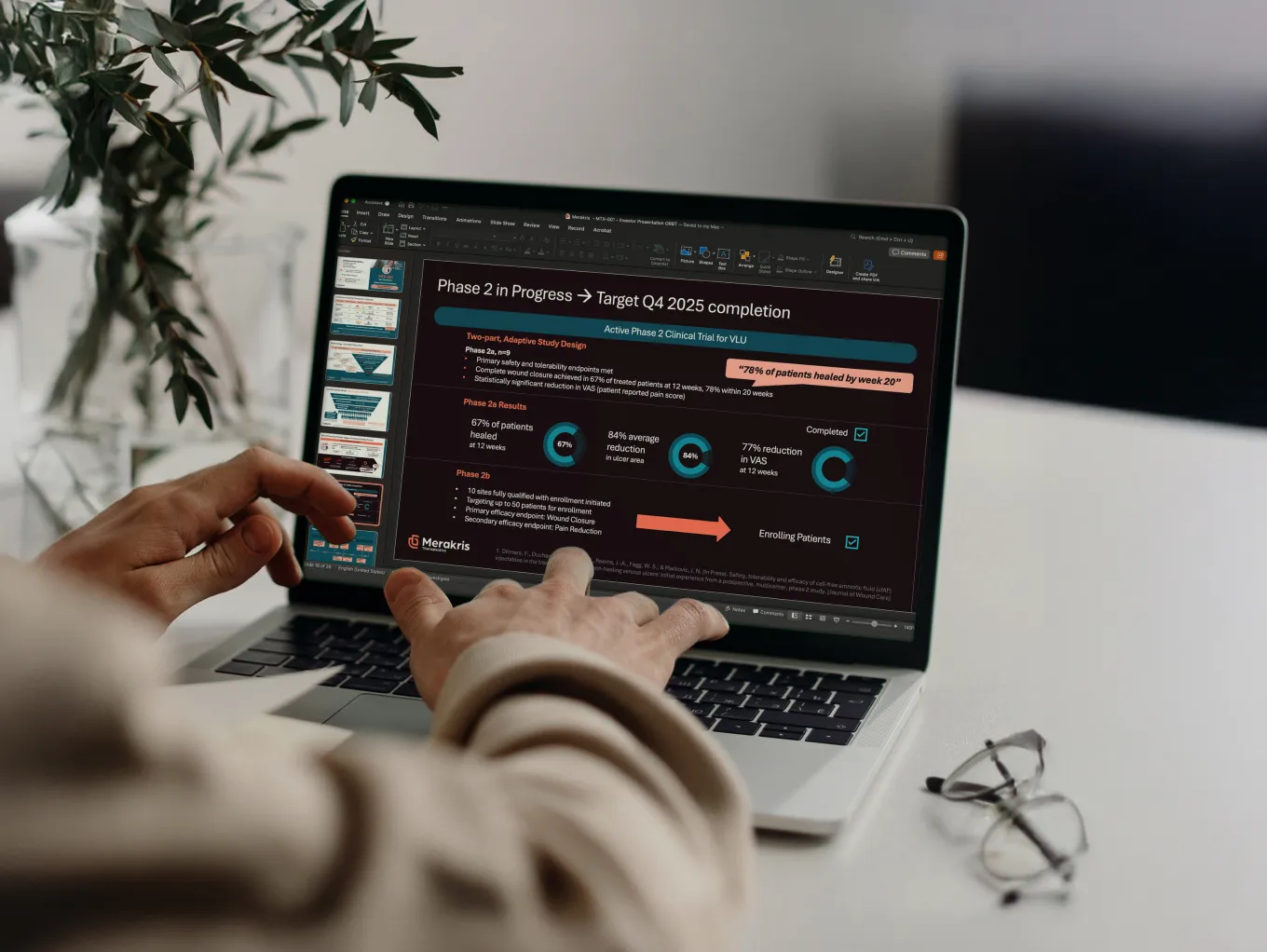 laptop screen with hands editing a powerpoint slide